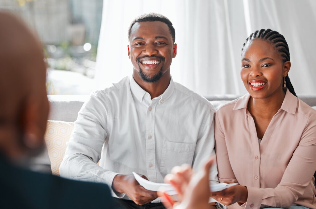 Shot of a young couple meeting with their home insurance agent